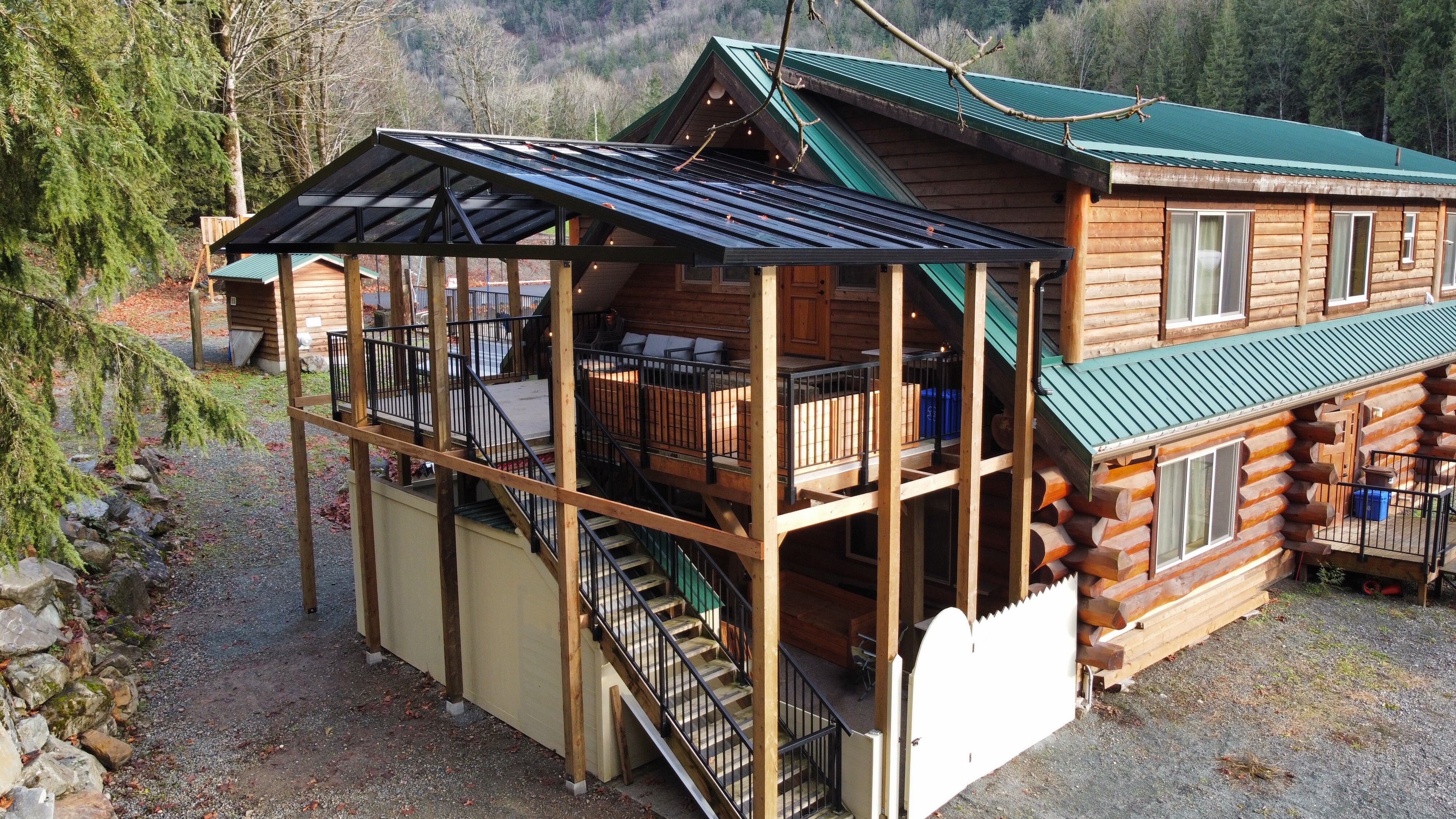 Aerial view of the log-built lodge, with its covered glass-roofed deck running the length of the building