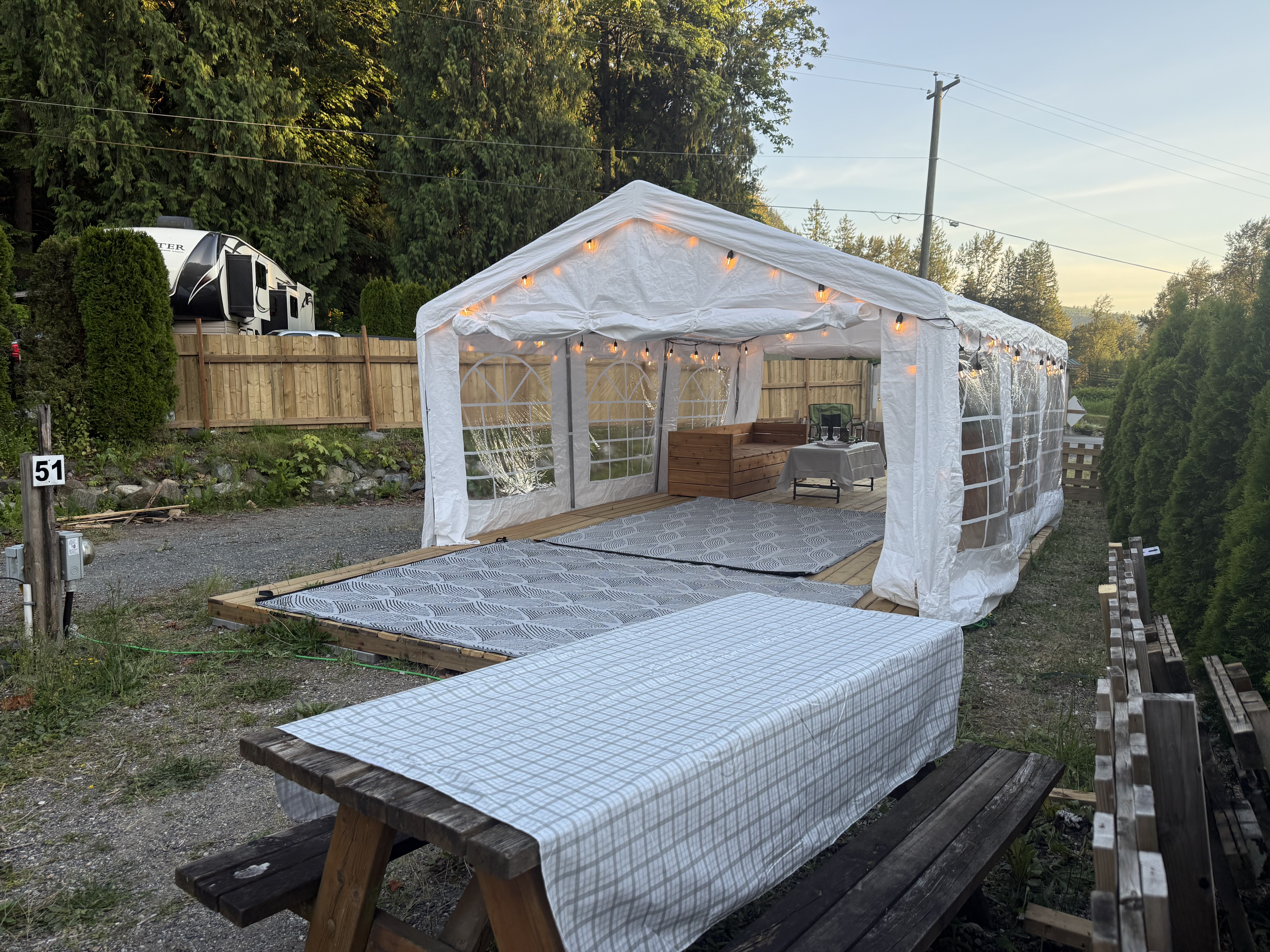 A picnic table beside the Pavilion with the deck and lights beyond